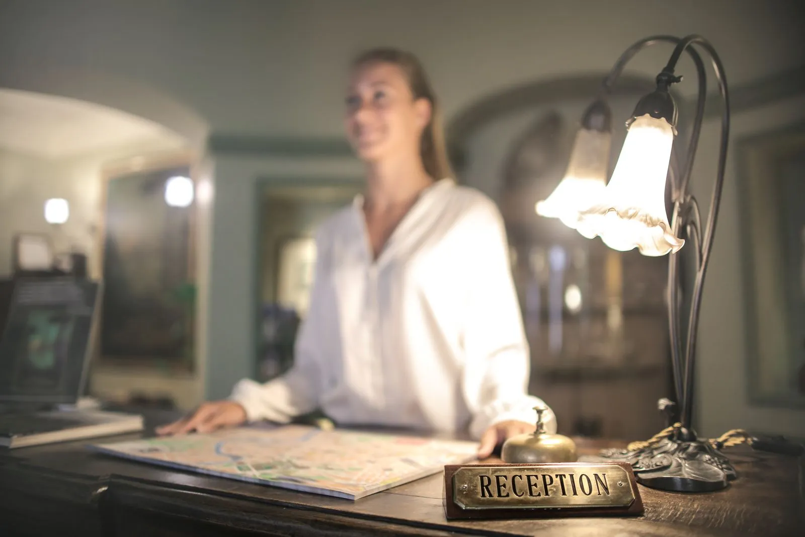 Recepcionista de hotel atendiendo en el mostrador de recepción